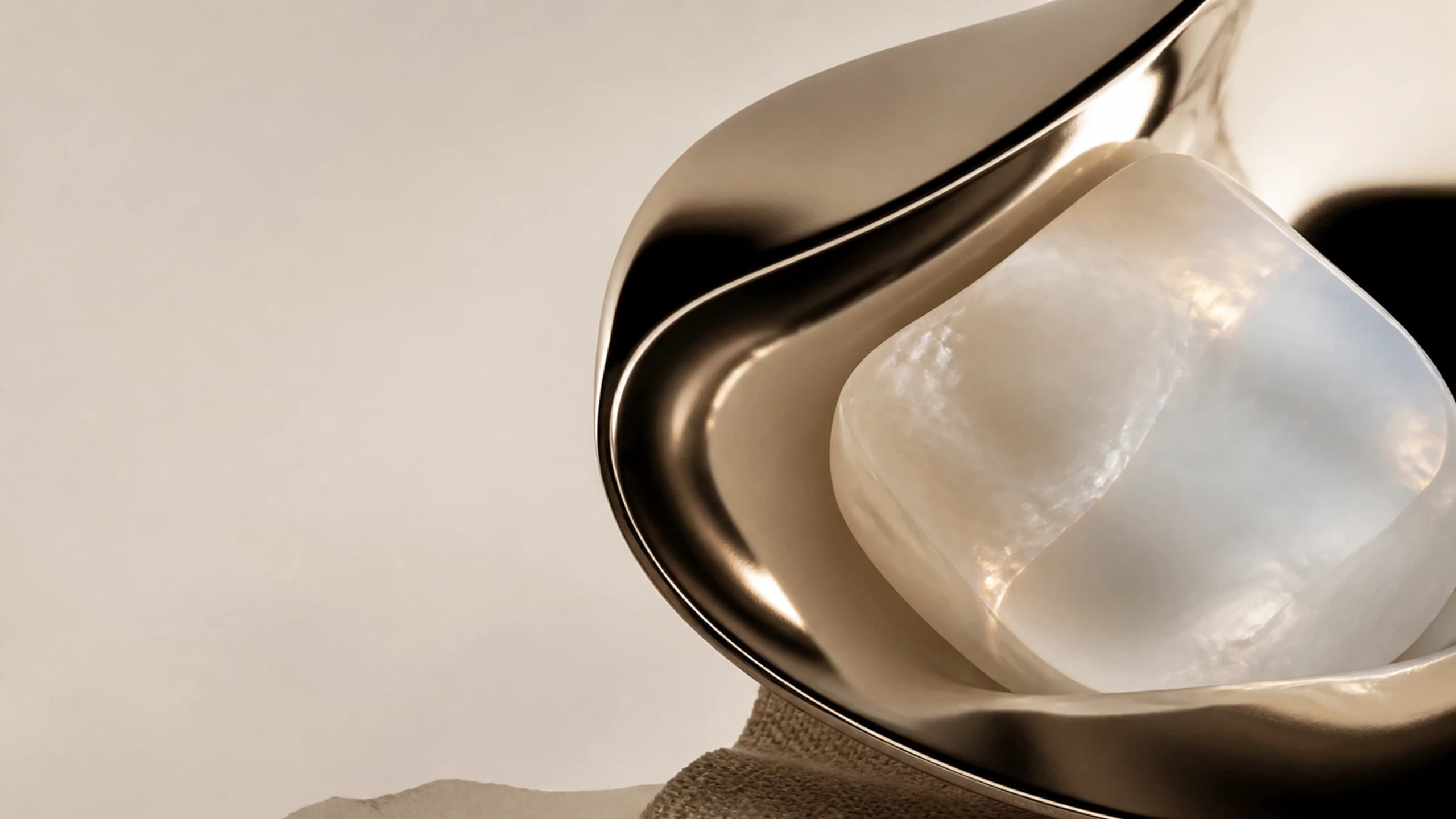 A broad mirror fold surrounding a milky opal centre above woven fibre
