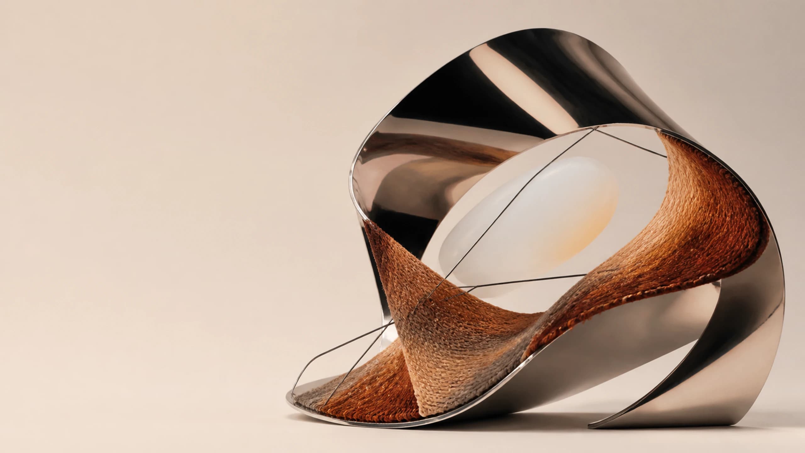 Mirror metal folds around a milky opal opening above a warm woven sweep