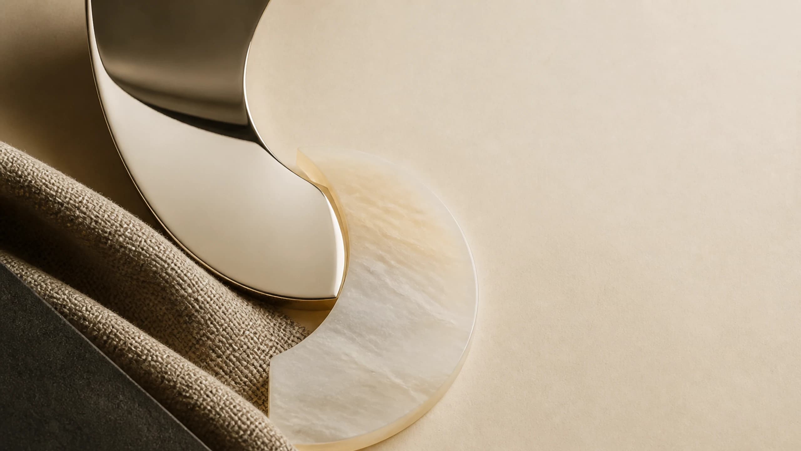 Two interlocking mirror and milky opal geometries balanced across woven fibre